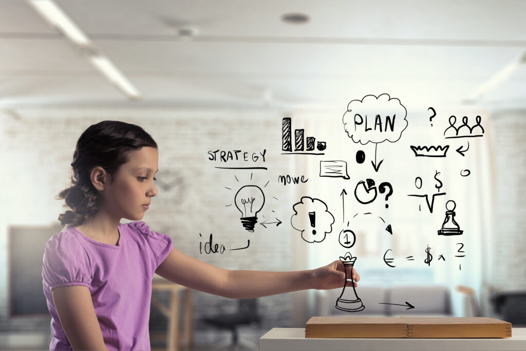 Girl holding a chess piece and imagining strategy and plans.